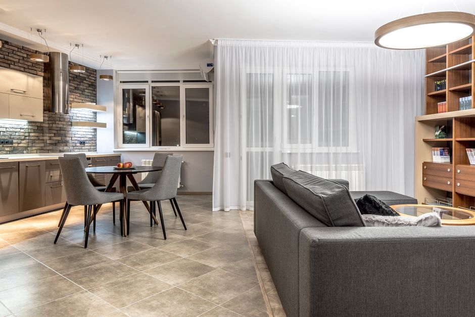 Elegant open-concept living room and kitchen with contemporary decor, emphasizing comfort and style.